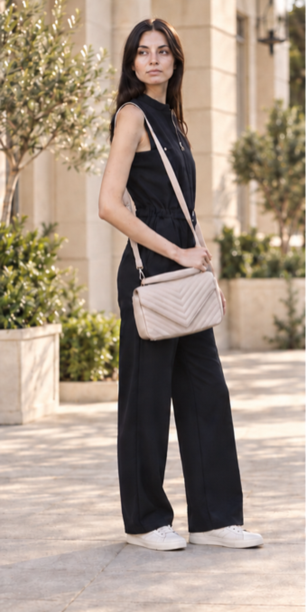 Woman carrying a cream Daisy Rose crossbody bag